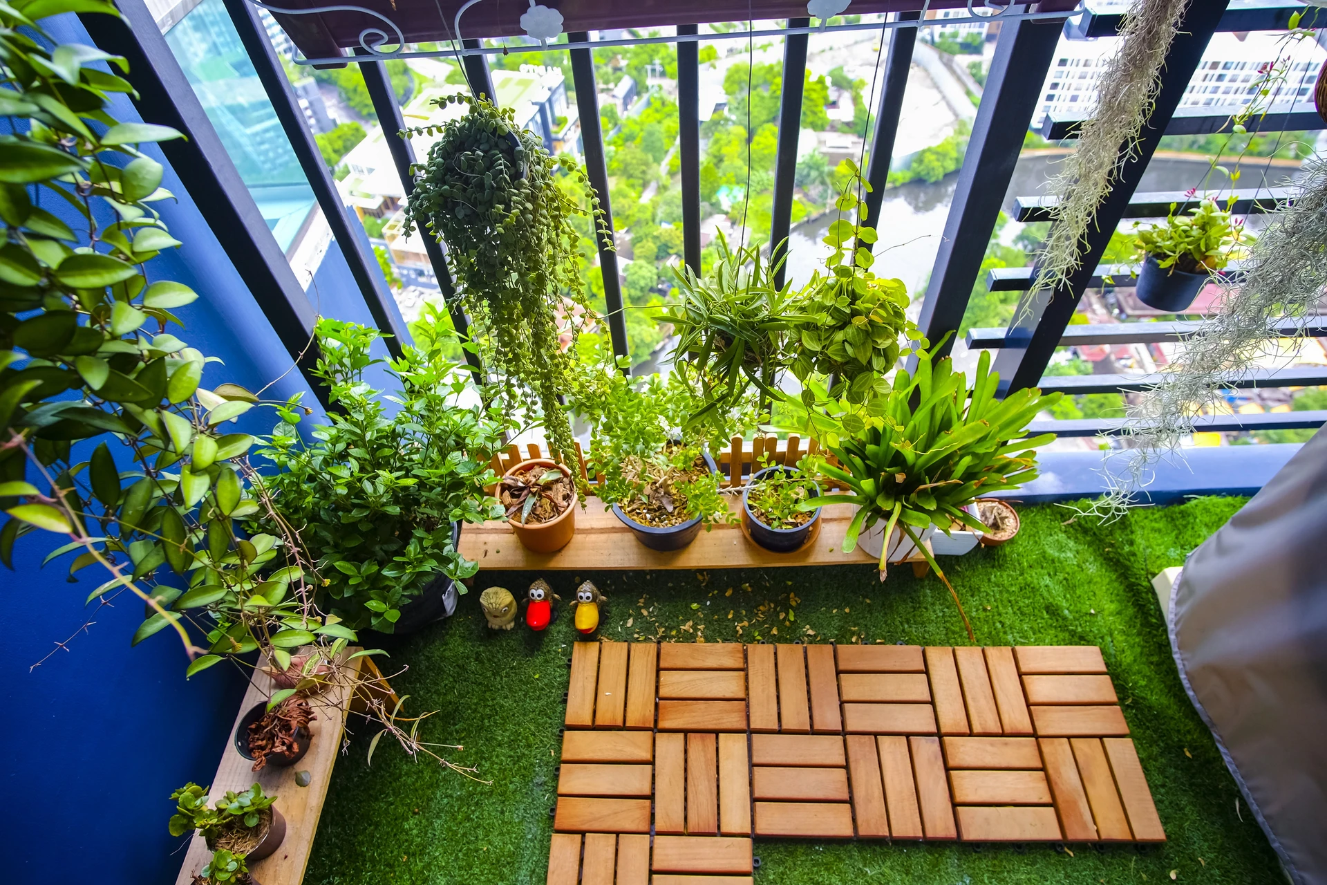 Balcon aménagé en jardin urbain avec plantes vertes suspendues et en pots
