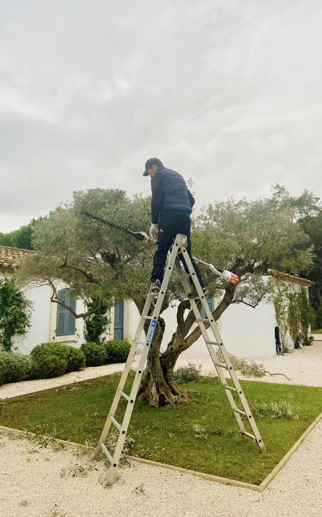 Scène extérieure d'entretien d'espaces verts avec deux personnes effectuant des travaux de jardinage