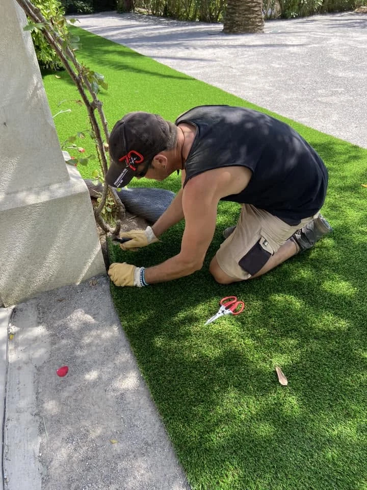 Terrasse extérieure en cours d'aménagement avec pose de dalles en pierre naturelle beige selon un motif géométrique irrégulier